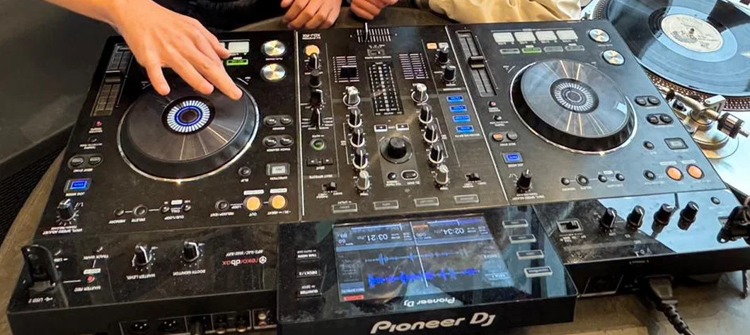Handen aan DJ-apparatuur
